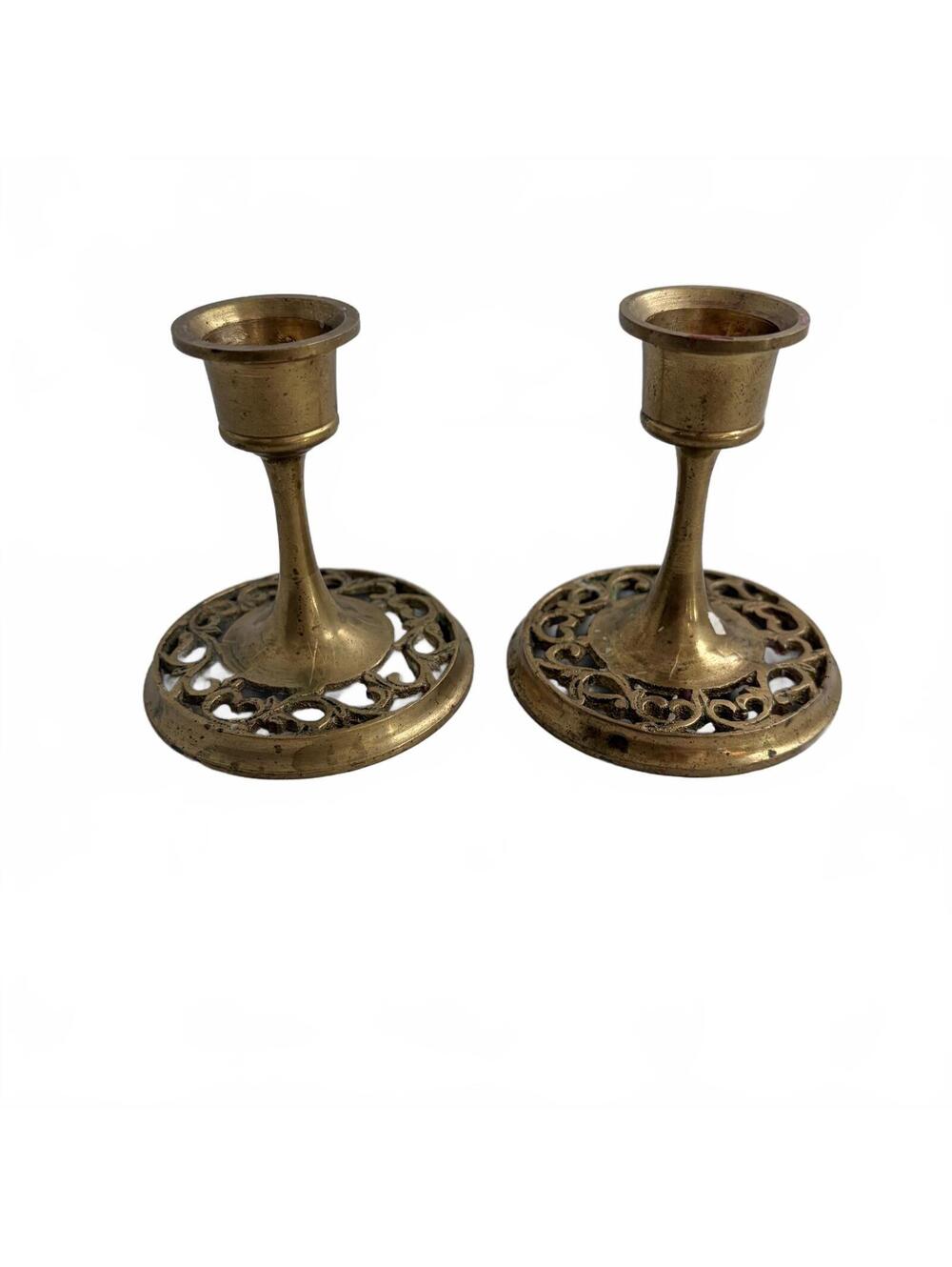 A pair of vintage ornate brass candlesticks with filigree bases.